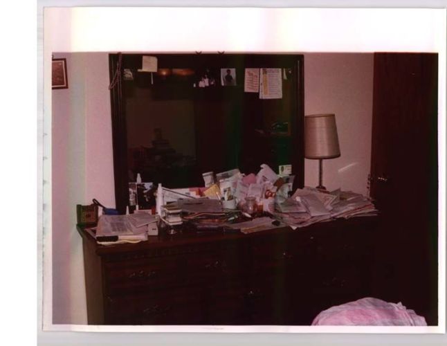 wide shot of dresser covered in papers and stuff