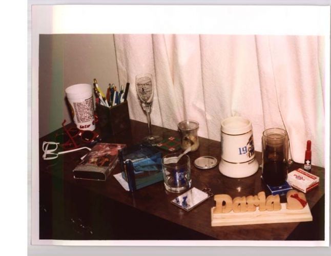 dresser covered in cups, sunglasses, and other knick knacks