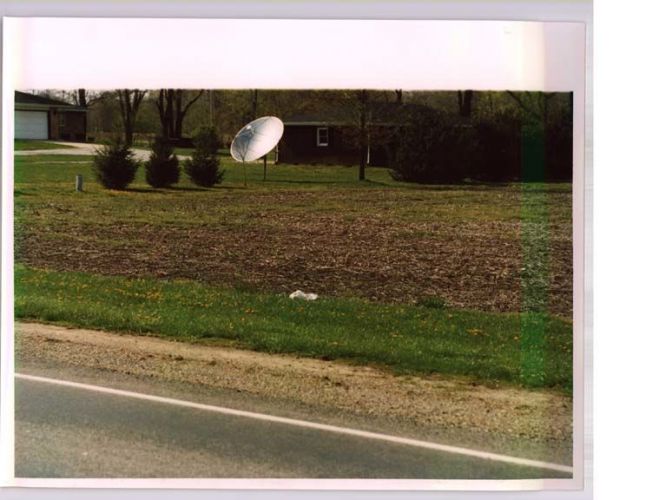 wide shot of white material in the grass near a road