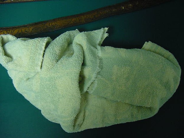 Evidence Photo of towel used to wrap John Welles’s firearm, belts and holster