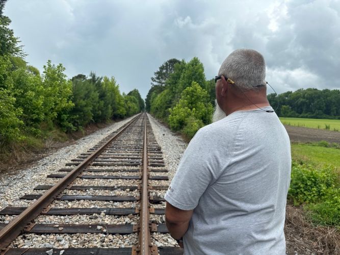 Andy Holliman standing on the railroad tracks